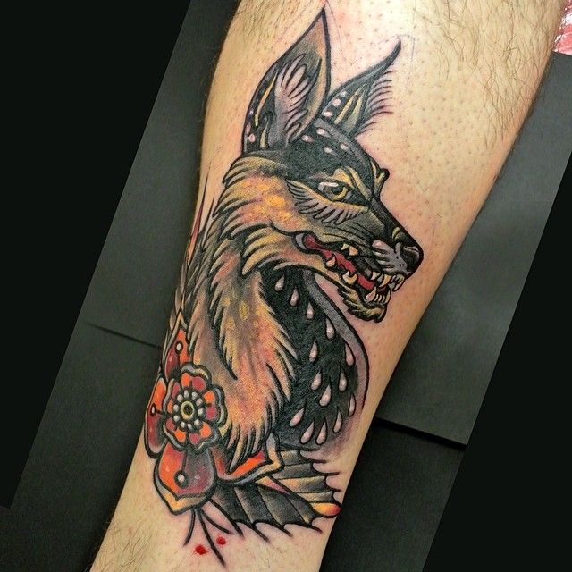 a man with a tattoo on his leg that has a wolf and flowers on it