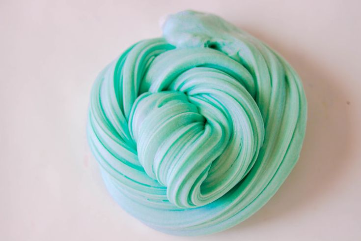 a ball of yarn sitting on top of a white table next to a green object