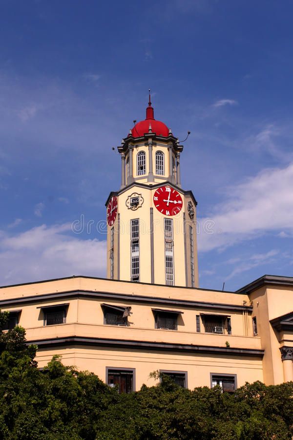 a clock tower on top of a building with trees around it and blue sky in the background