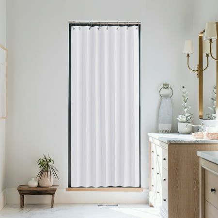 a white shower curtain in a bathroom next to a sink and vanity with a potted plant on the counter