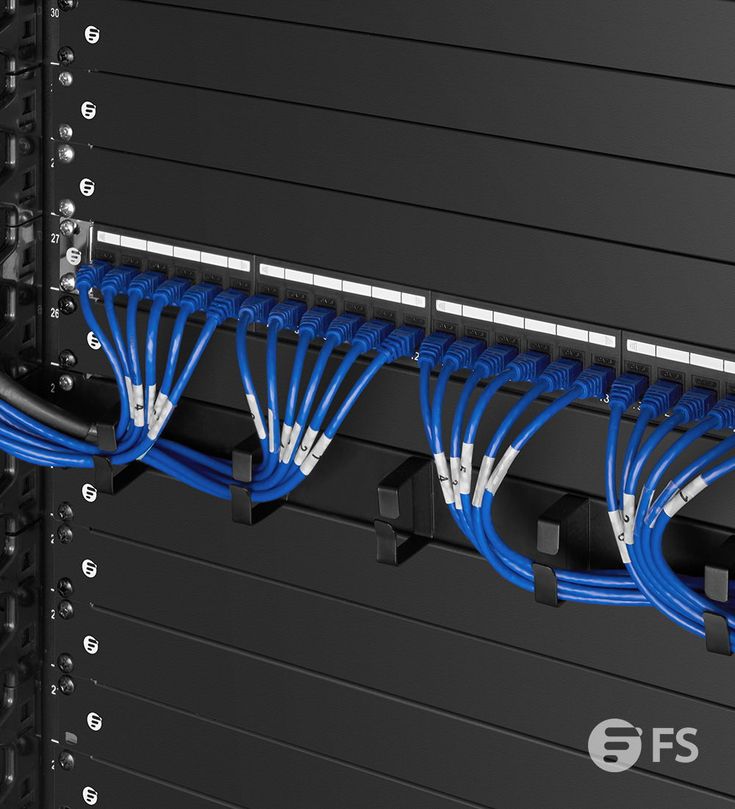 several blue cables are connected to the back of a server's rack in a data center