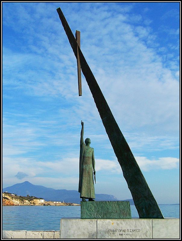 there is a statue with a cross in the middle of it and water behind it