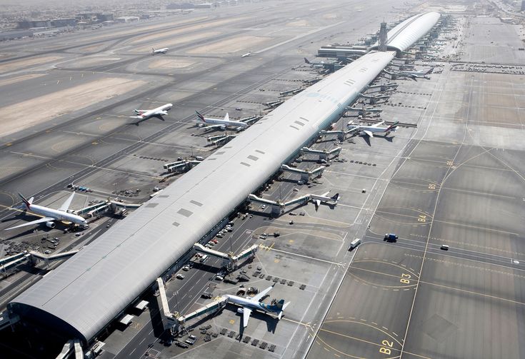 an airport filled with lots of airplanes on top of tarmac next to each other