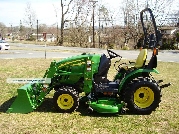 a green tractor parked on top of a lush green field