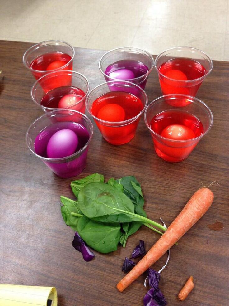 several cups filled with different colored liquids and vegetables