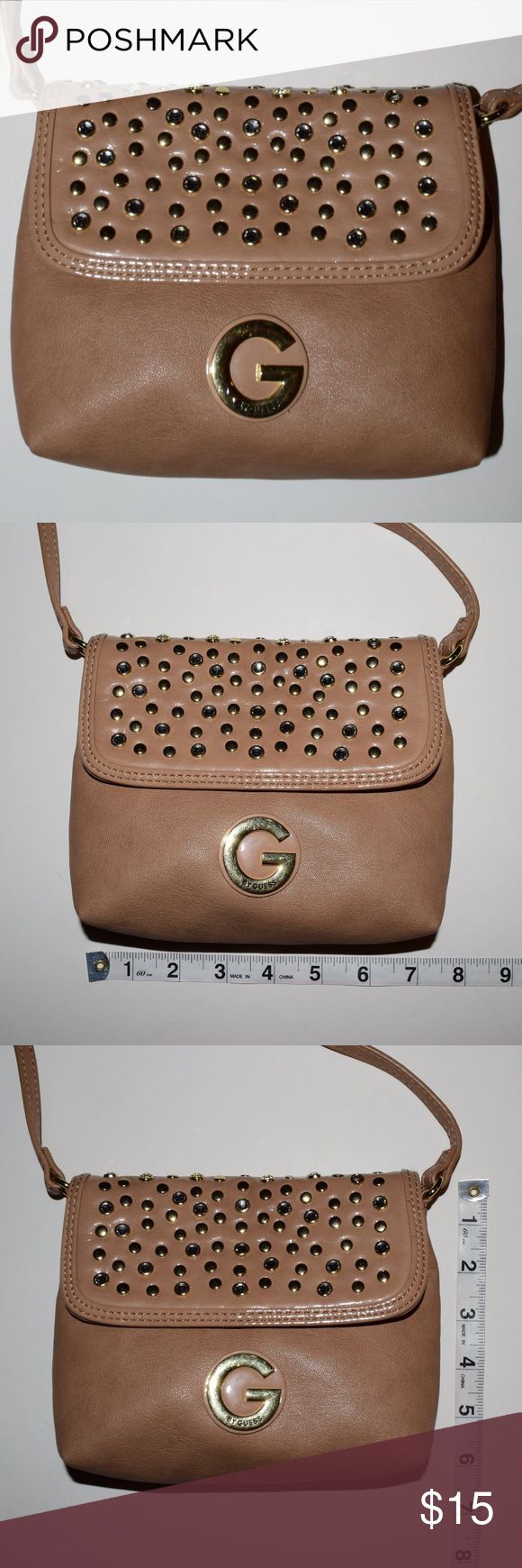 G by Guess Tan Studded Crossbody Bag Has studs all along the top flap. These add a lot of detail to the bag. It is 7.5"  in length and 6" tall  The inside is black with white polka dots and has a zipper pocket. The back of the purse has some markings on the top right corner, but it isn't visible when wearing G by Guess Bags Crossbody Bags Guess Bags Crossbody, Guess Bags, Moving Sale, Black Polka Dot, White Polka Dot, Saddle Bags, On The Top, Crossbody Bags, Zipper Pocket