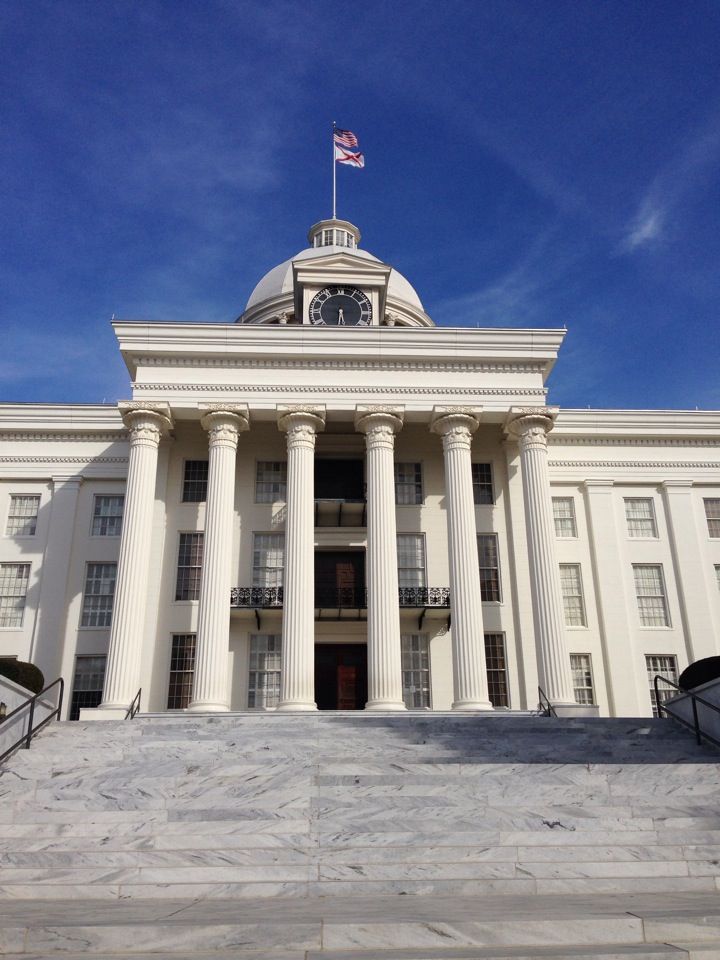 a large white building with columns and a clock on top