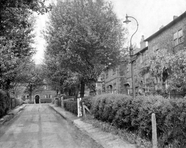 an old black and white photo of a street lined with houses in the early 1900's