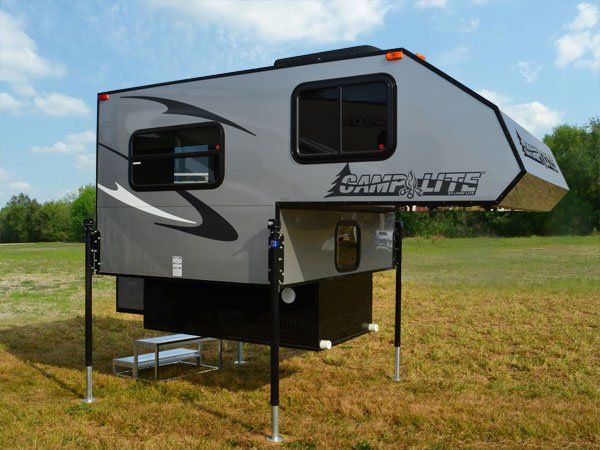 the camp lite trailer is parked in a field