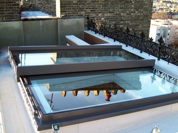 the roof is covered in glass and has been placed on top of an apartment building