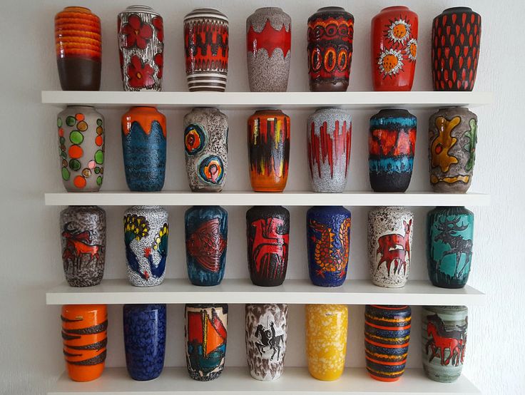 many different colored vases are arranged on shelves