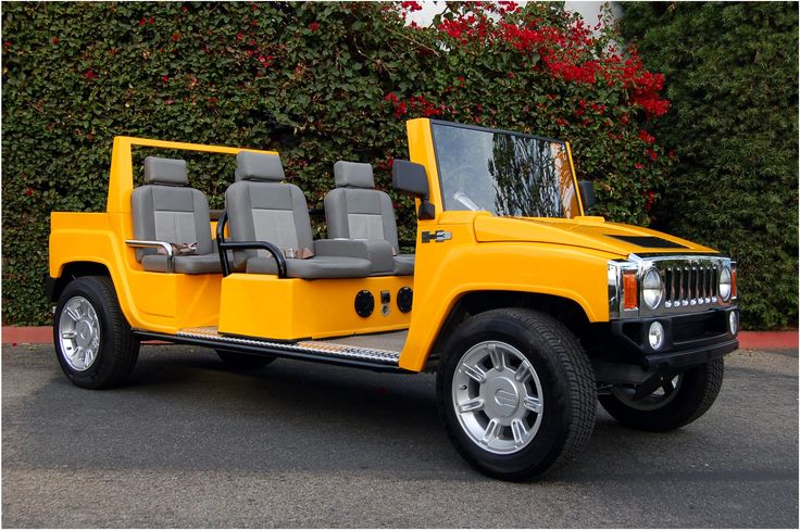 a yellow jeep is parked in front of some bushes