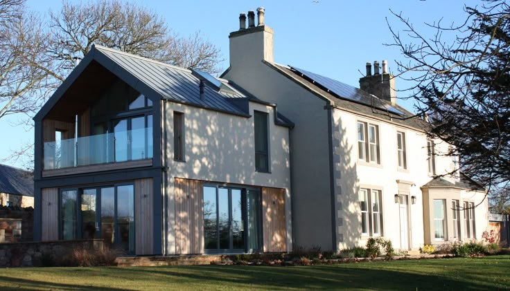 a large house sitting on top of a lush green field