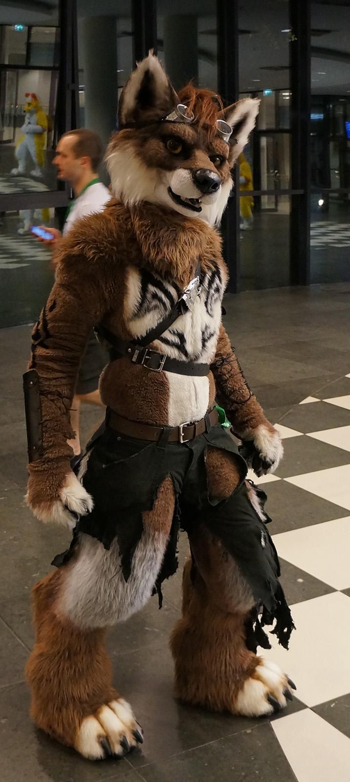 a man dressed as a fox standing on a checkered floor