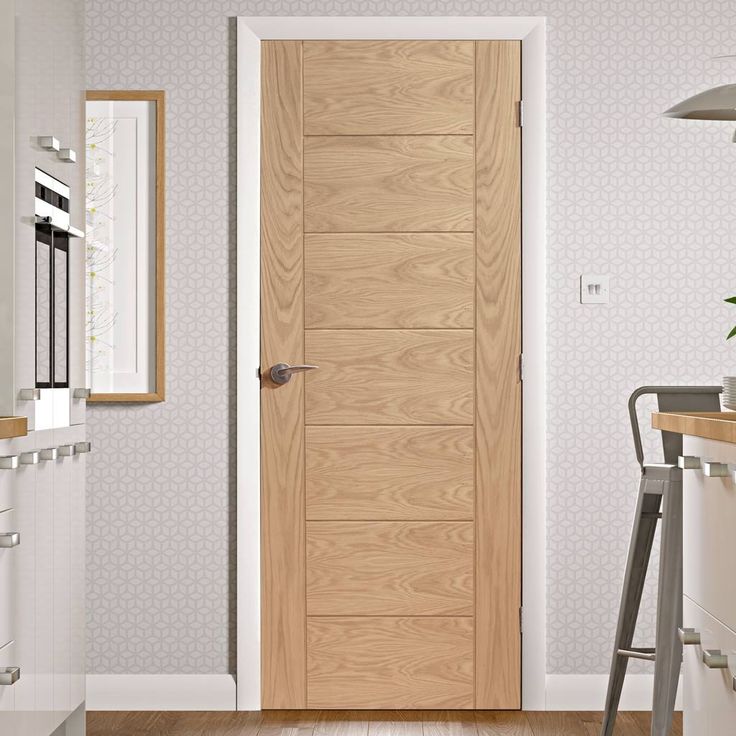 an open wooden door in a white kitchen