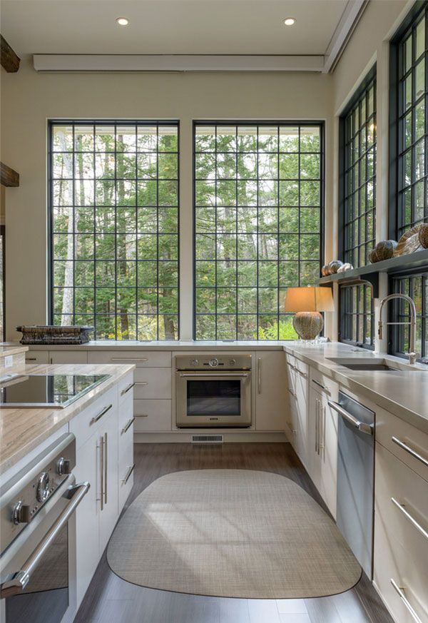 a kitchen with lots of counter space and windows above the stove, sink, and dishwasher