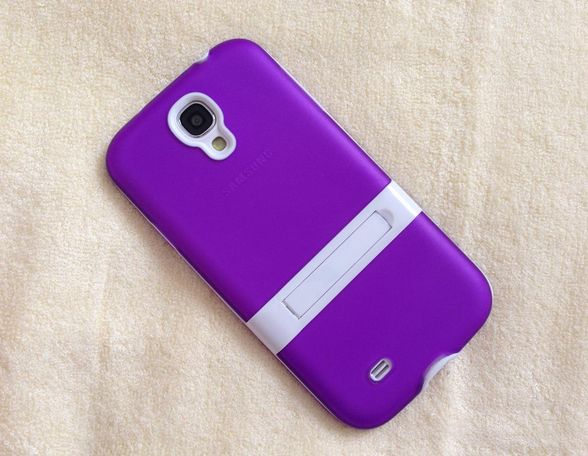 a purple cell phone laying on top of a white blanket