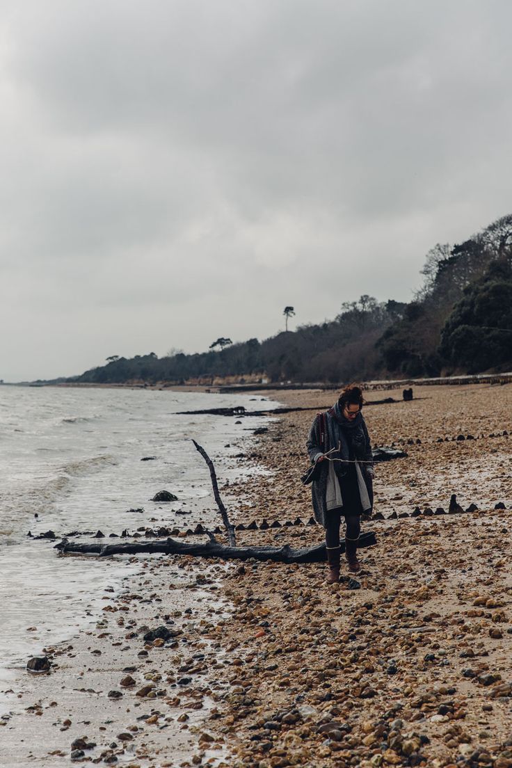 a man standing on top of a beach next to the ocean