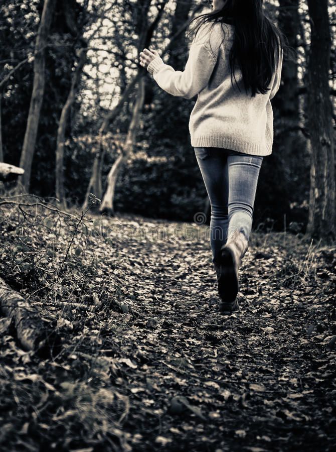 a woman running through the woods in black and white stock photo - image 34987