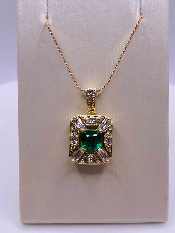 18k Yellow Gold .66 Carat Emerald-cut emerald, 4=.33 carat total weight baguette diamond, 13=.24 carat total weight round brilliant cut Diamond Pendant. 2.6Dwt Fine Jewelry Emerald With Baguette Diamonds, Fine Jewelry With Baguette Diamonds And Emerald, Luxury Diamond Cut Emerald Necklace For Anniversary, Luxury Gold Emerald Necklace With Brilliant Cut, Baguette Cut Diamond Emerald Necklace For Anniversary, Luxury Baguette-cut Emerald Necklace For Formal Occasions, Luxury Baguette Cut Emerald Necklace For Formal Occasions, Green Baguette Diamond Jewelry For May Birthstone, Luxury Cubic Zirconia Emerald Necklace For Anniversary