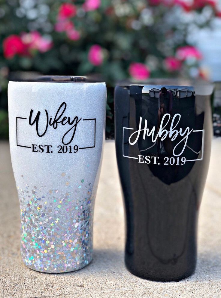 two black and white tumblers sitting next to each other on top of a table