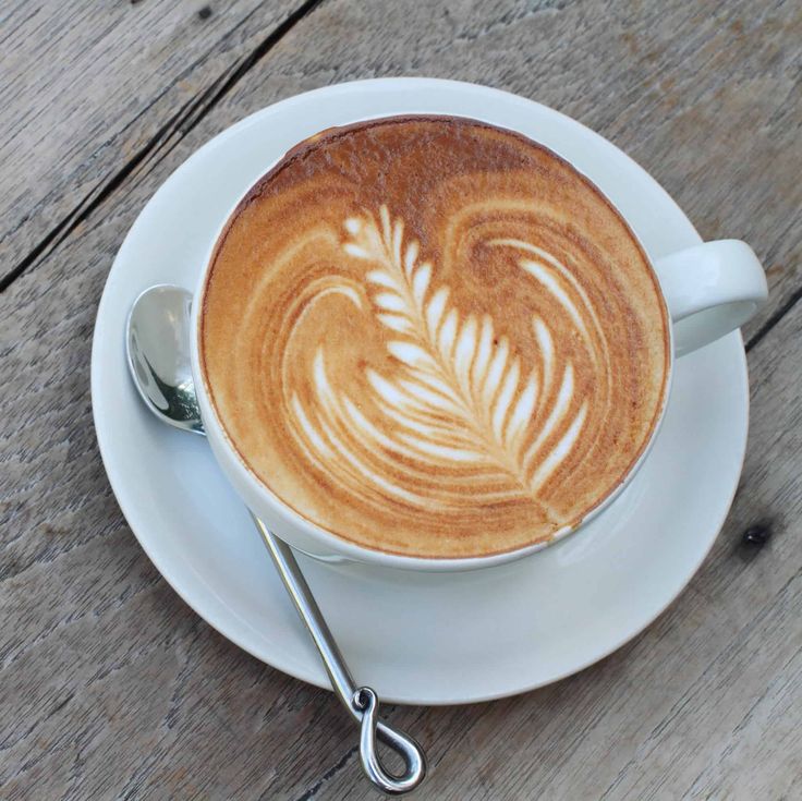 a cappuccino on a saucer with a spoon