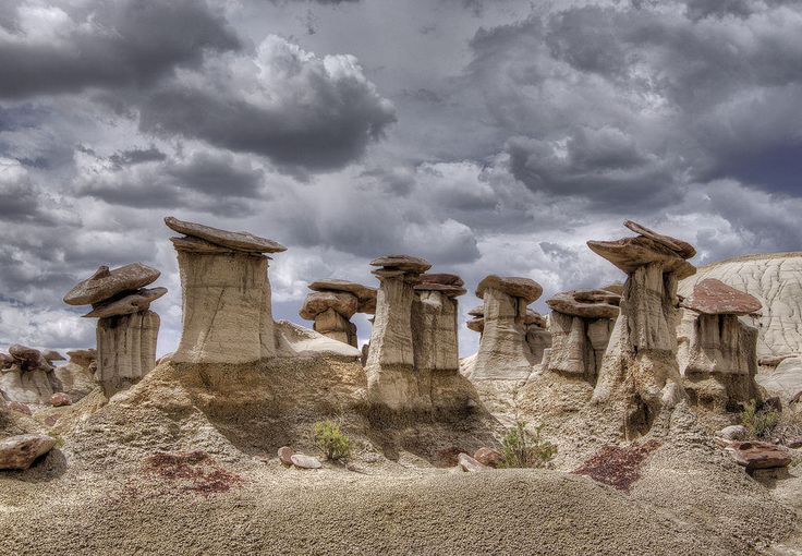 the rock formations are covered in moss and rocks under a cloudy sky with dark clouds