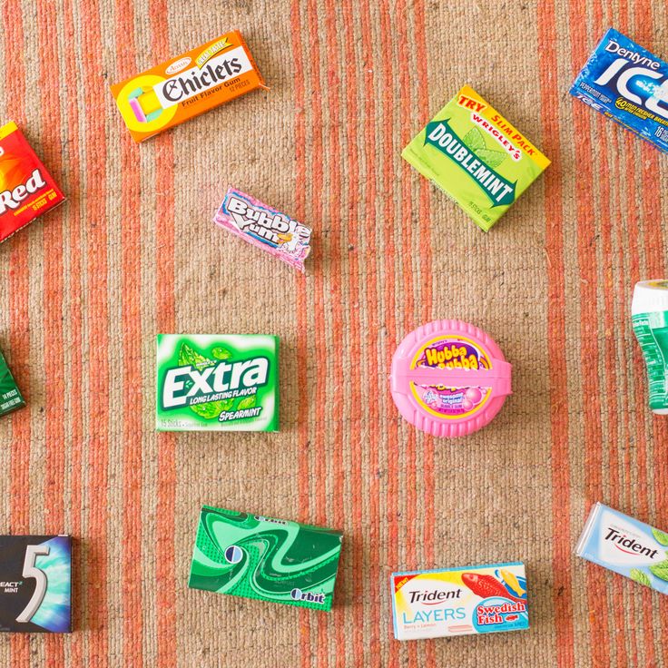 many different types of candy on a carpeted floor with orange and white stripes behind them