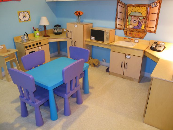 a child's playroom with blue and purple chairs, wooden counters and cabinets