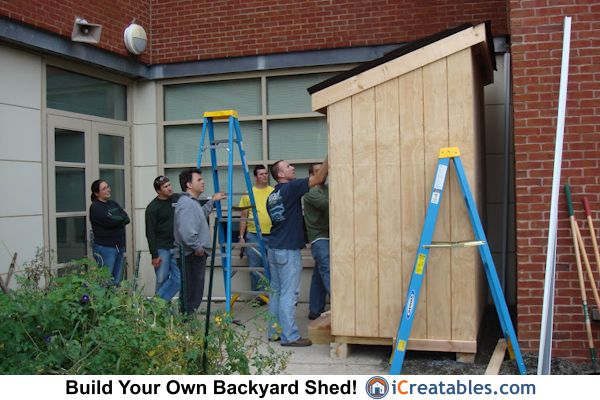 several men are standing around in front of a building that has been built into the ground