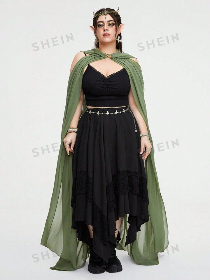 a woman in a black dress and green cape is standing with her hands on her hips