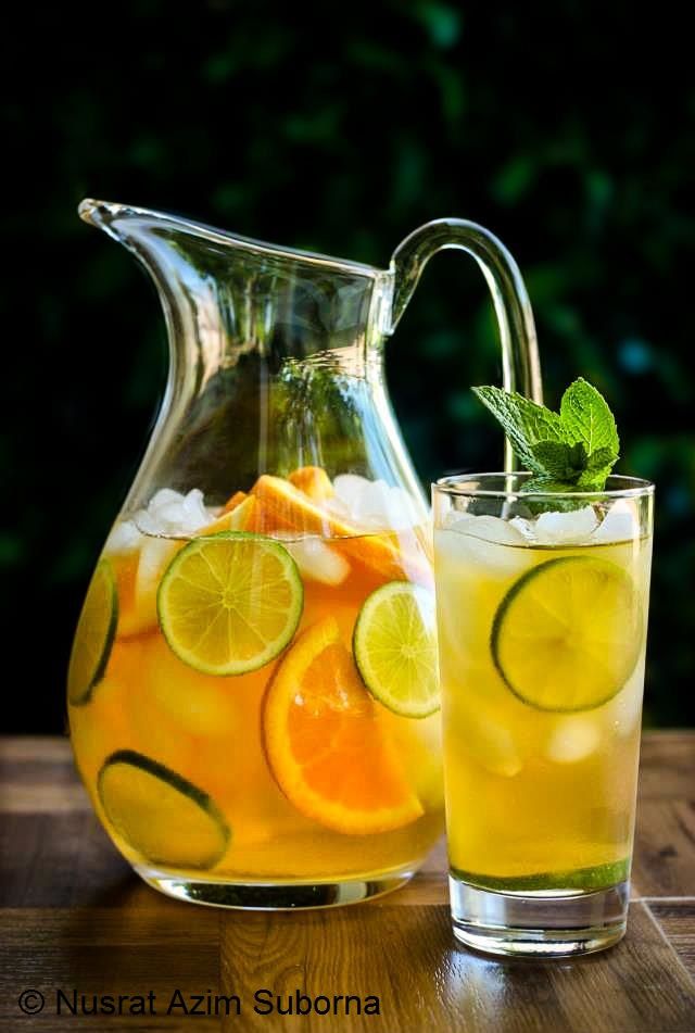 a pitcher and glass filled with lemonade on top of a wooden table next to each other