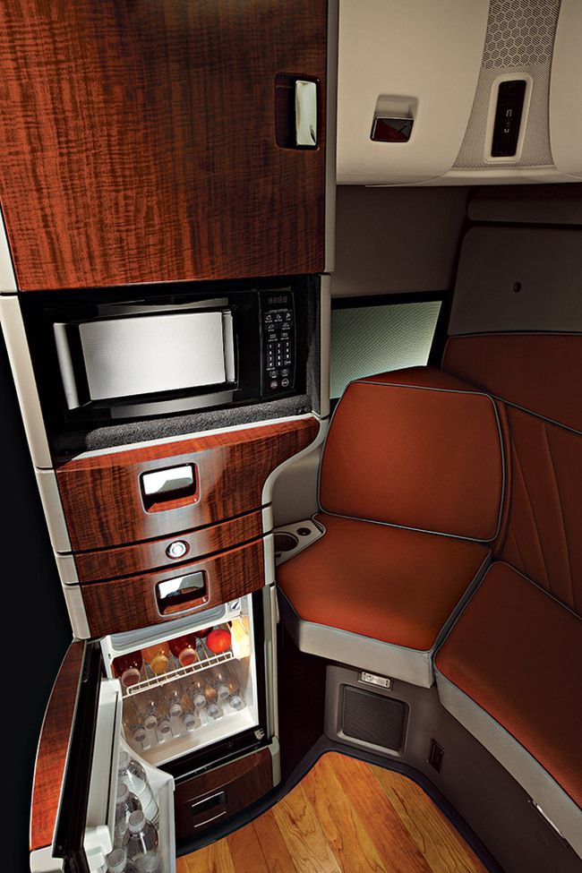 the interior of an airplane with wood paneling and red leather seat covers on it