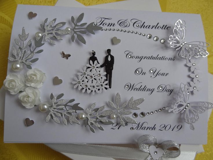 a wedding card with white flowers and butterflies on the front, and an image of a bride and groom holding hands