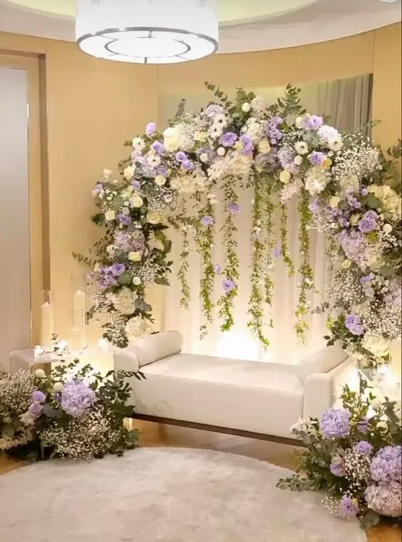 a white couch sitting under a flower covered arch