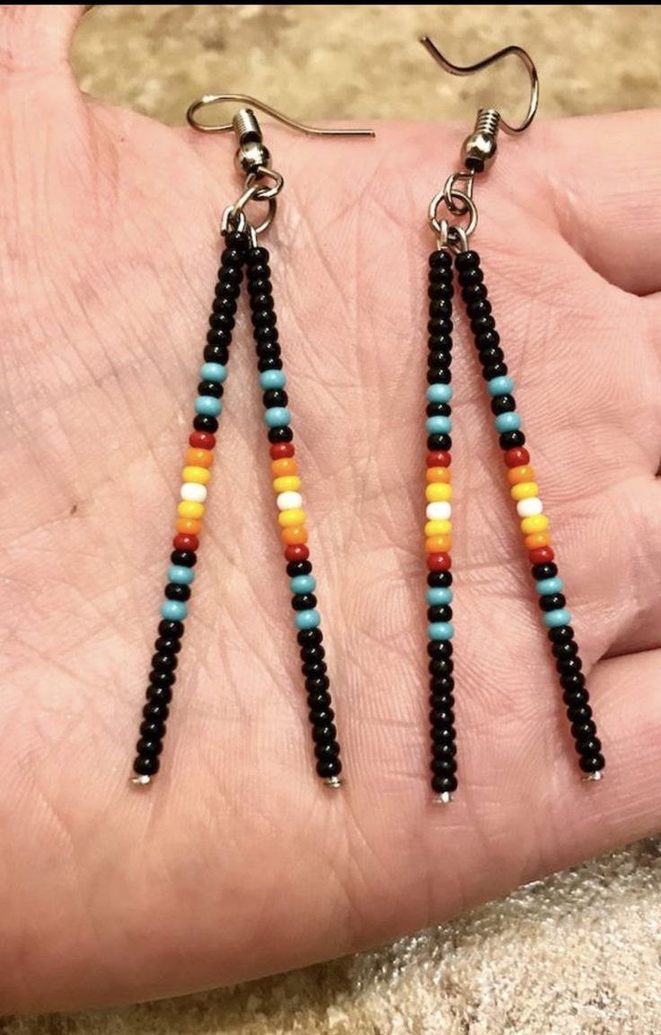 a pair of beaded earrings on someone's hand