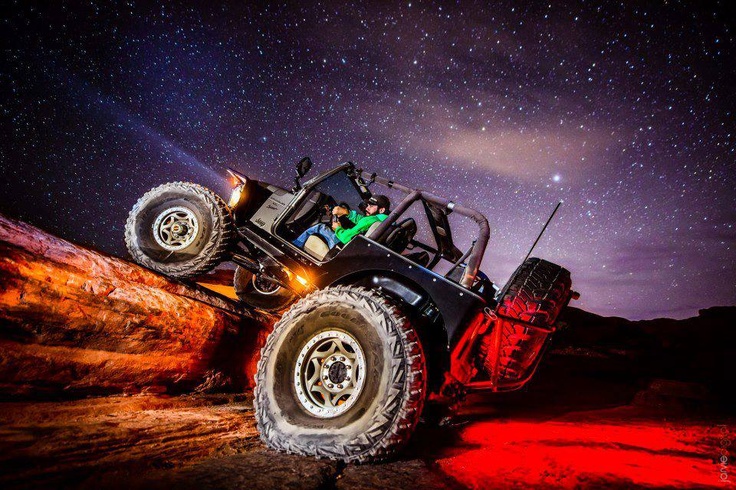 an off - road vehicle driving through the night sky