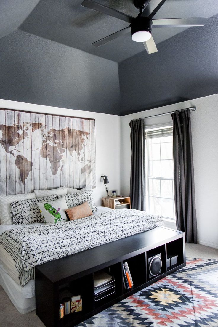 a bed room with a neatly made bed and a map on the wall above it