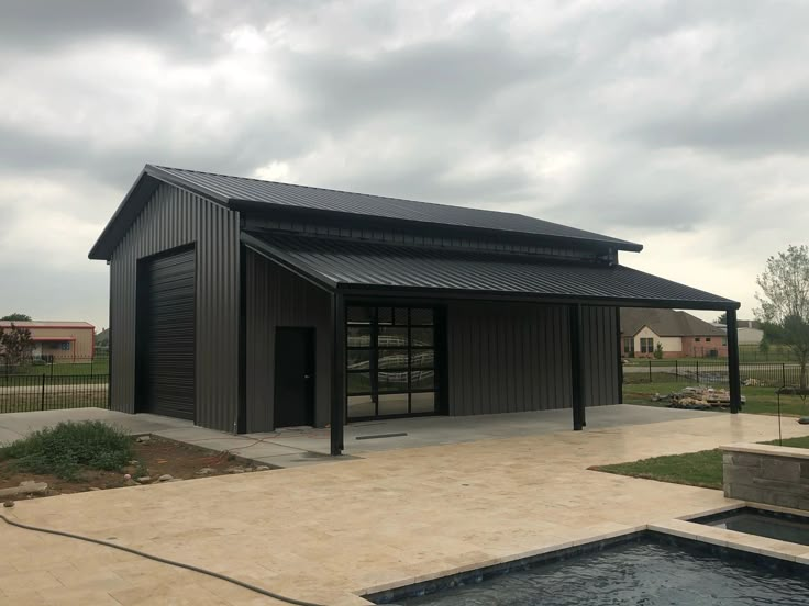 a small building with a hot tub in the foreground and an empty pool behind it