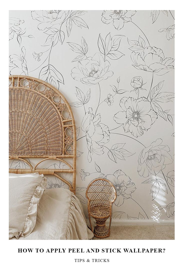 a bedroom with floral wallpaper and wicker chair next to the headboard on the bed