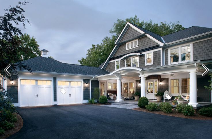 a large house with two garages and an open front door on the side of it