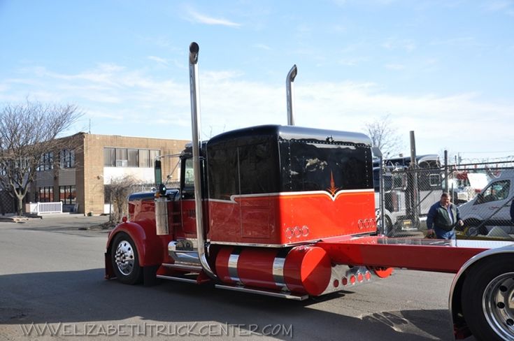 a red semi truck is parked on the side of the road