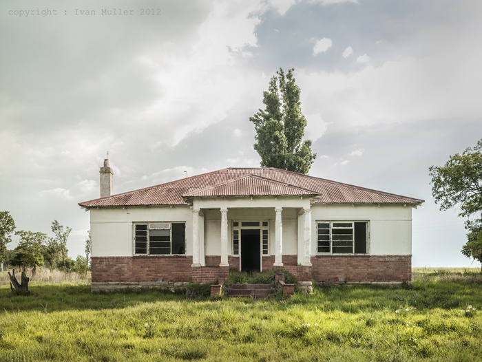 an old house in the middle of a field