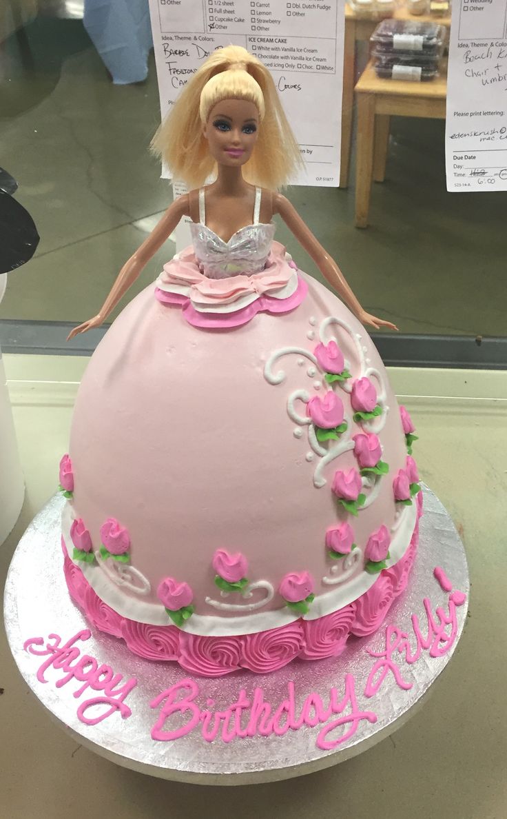 a barbie doll birthday cake with pink frosting