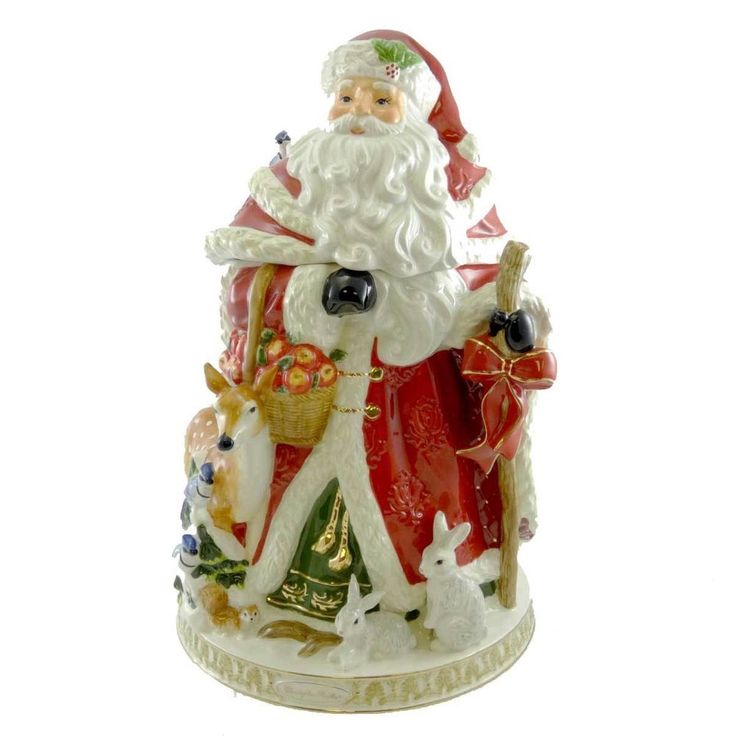 a santa clause figurine sitting on top of a christmas tree ornament