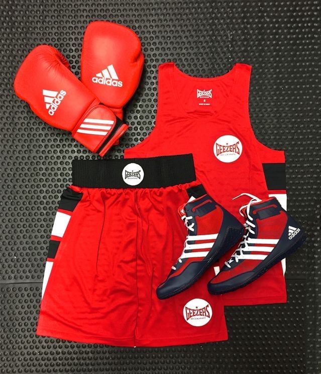 a pair of boxing gloves, red shorts and adidas shirt