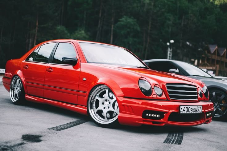 a red car parked in a parking lot next to other cars