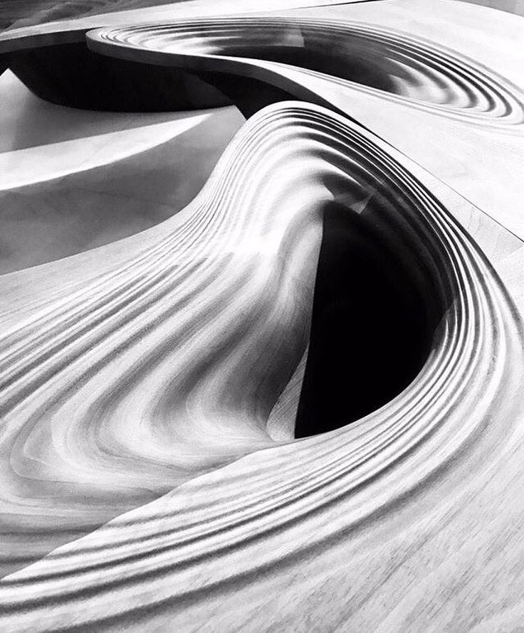 a black and white photo of an abstractly designed building with wavy ...