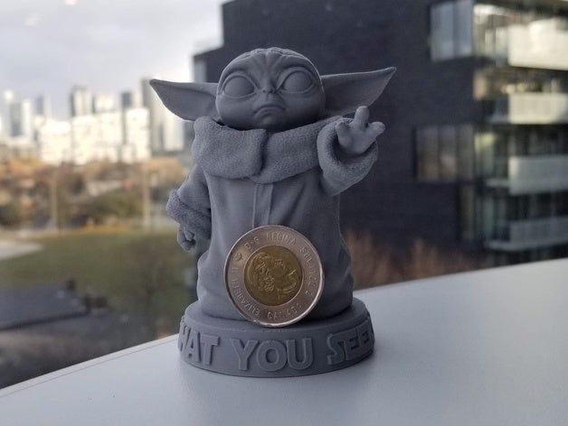 a star wars yoda figurine on top of a table