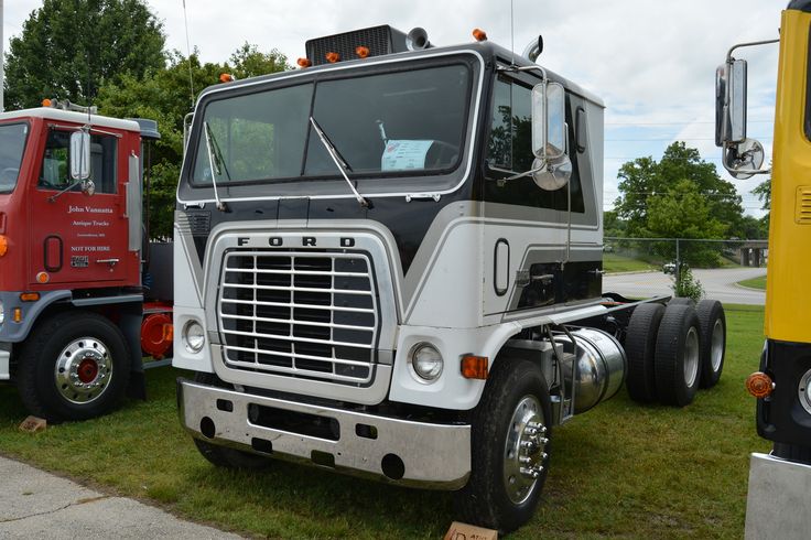 two large trucks parked next to each other on the grass